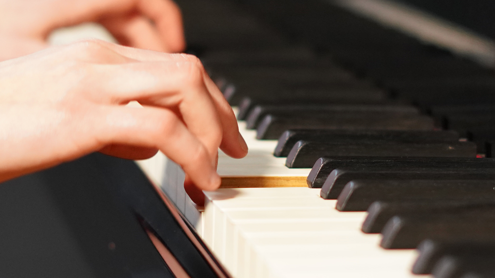 Eine Hand drückt eine Taste auf einem Klavier