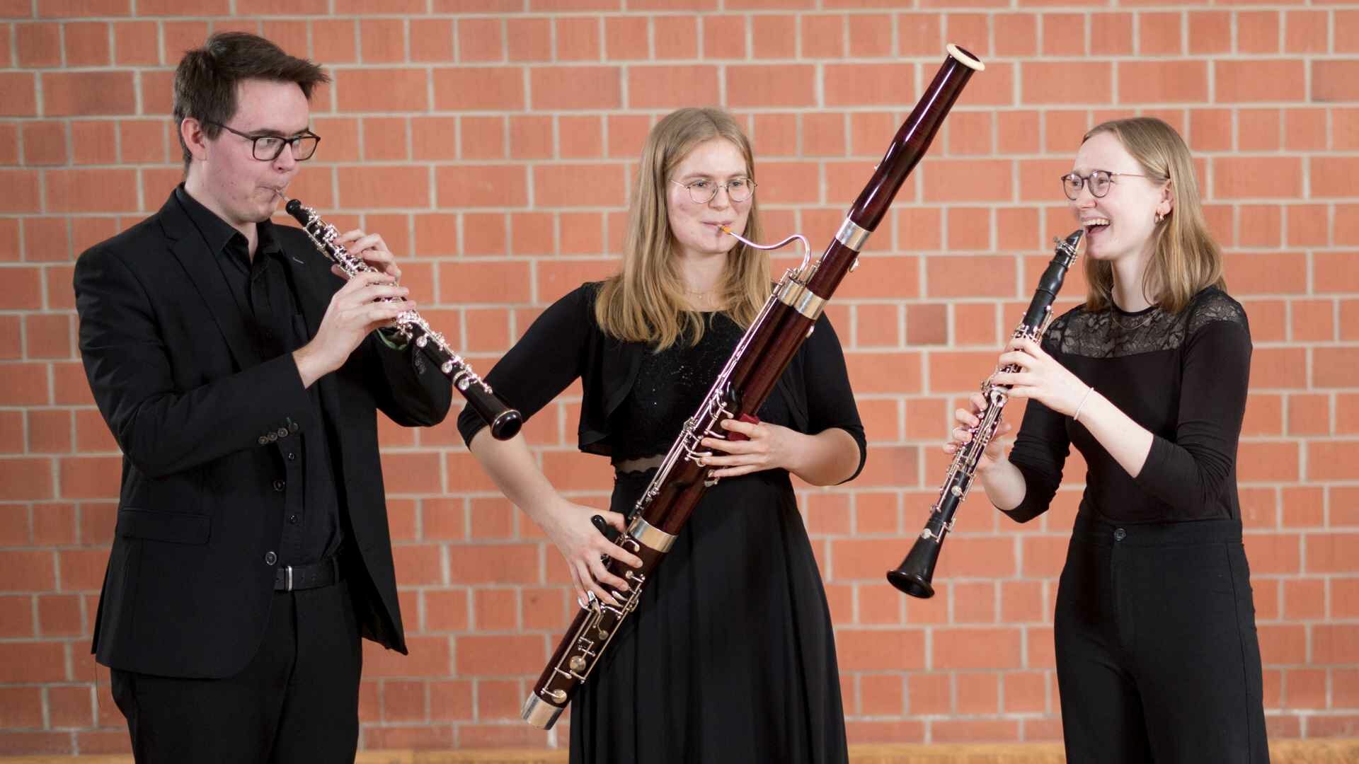 Drei Studierende mit Oboe, Fagott und Klarinette musizieren gemeinsam