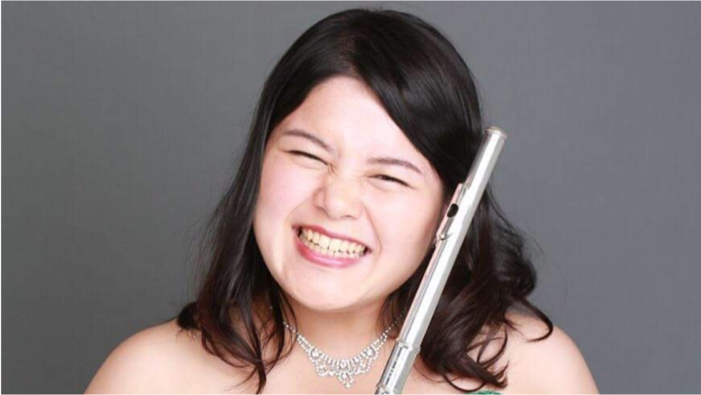 Lachende Yui Sakata mit ihrer Querflöte
