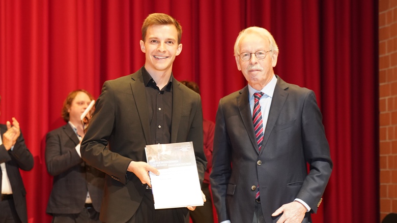 Niklas Jahn bekommt auf der Bühne seine Urkunde von Dr. Ulrich Keller