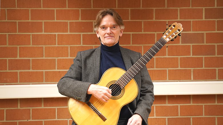 Porträt von Michael Hampel mit Gitarre