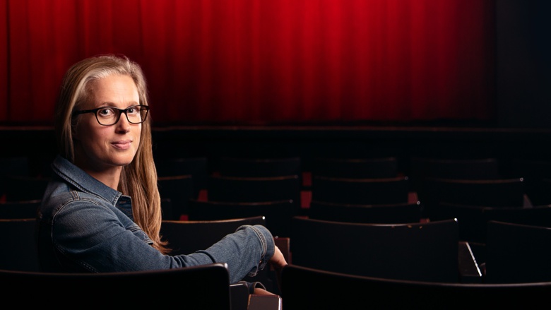 Nicola Gess sitzt in einem leeren Theatersaal