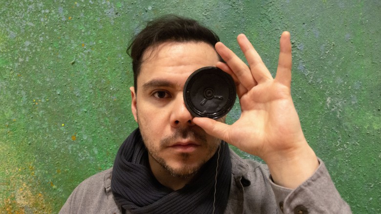 Sebastian Zuleta mit einem kleinen Lautsprecher vor dem einen Auge