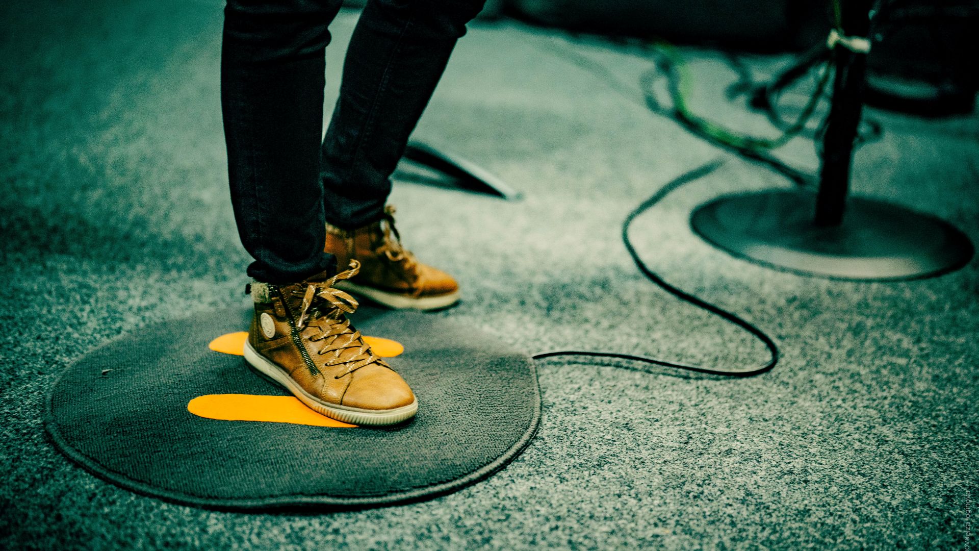 Füße halb auf, halb neben einer Fußmatte mit Kabel