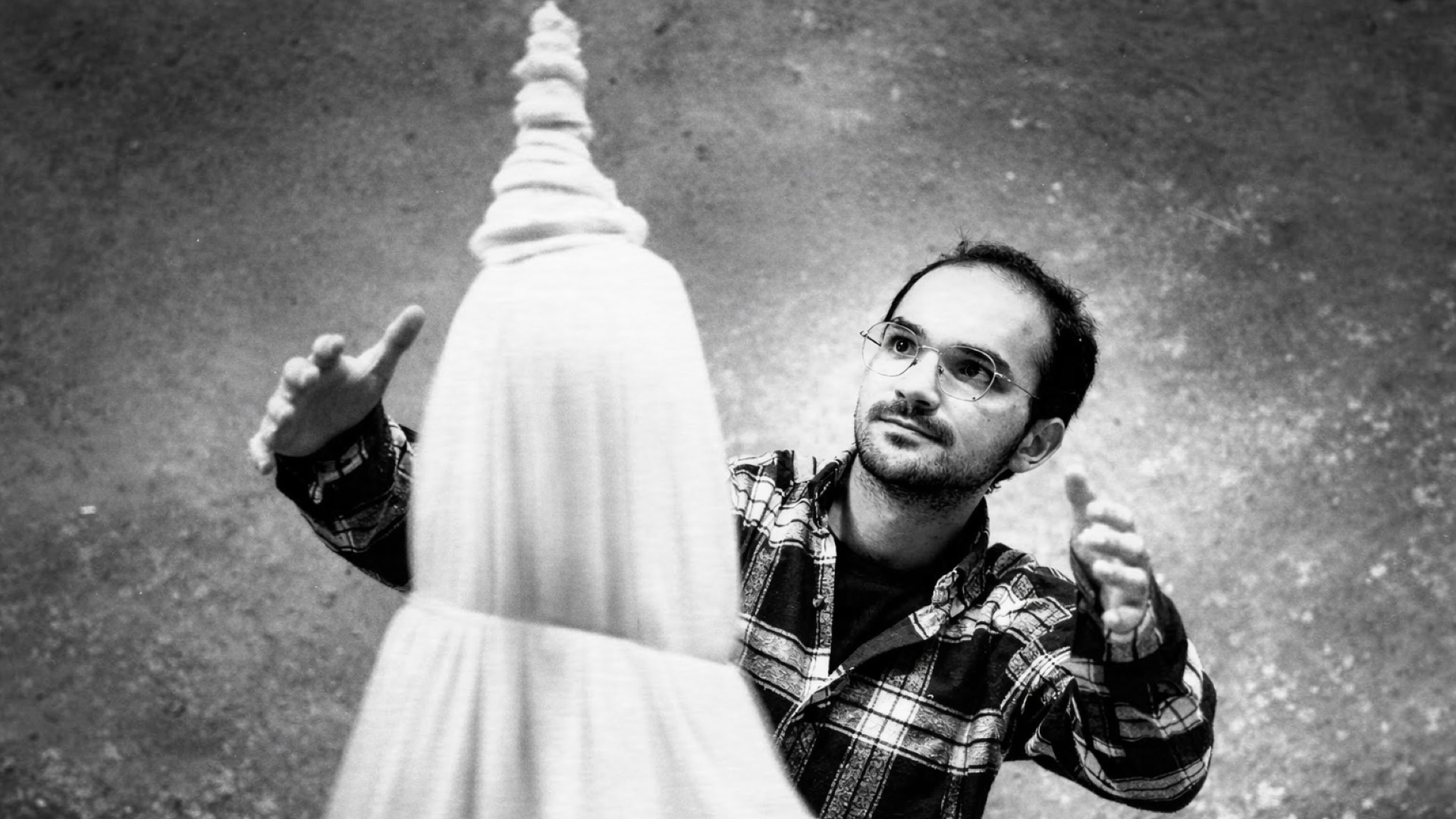 İlyas Talha Güneş seitlich hinter der Figur eines tanzenden Derwischs, zu der er die Arme hochreckt