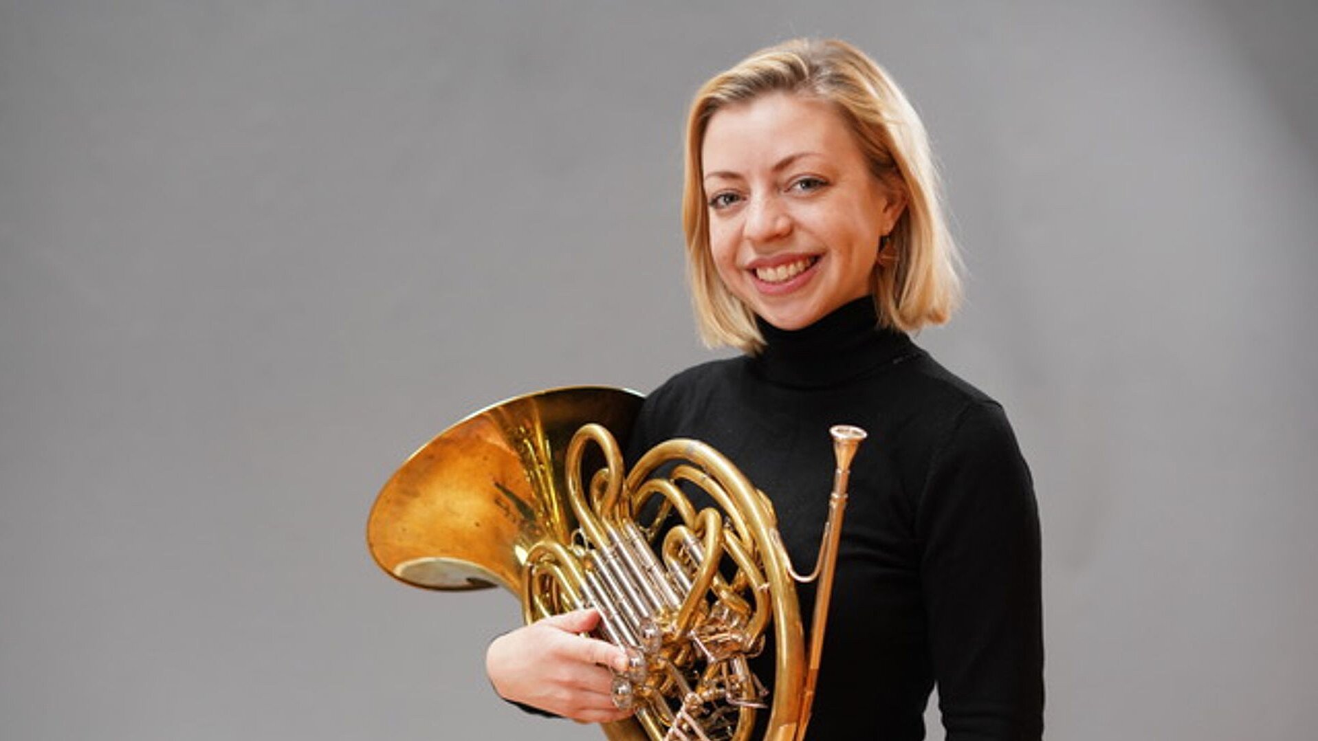 Lena Widdermann in einem schwarzen Pullover mit einem Horn in der Hand