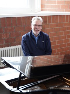 Helmut Lörscher hinter einem Flügel in der Hochschule