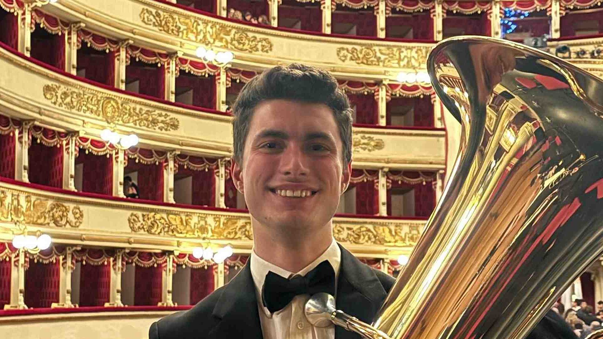 Sebastian Zani im schwarzen Anzug mit Fliege vor den Rängen der Mailänder Scala mit Tuba in der Hand