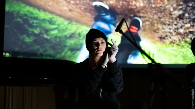 Frau mit Mütze und weiße Handschuhe vor Mikrophon