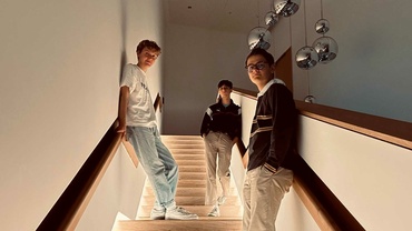 Linus Rebmann steht mit seinem Trio auf einer Treppe