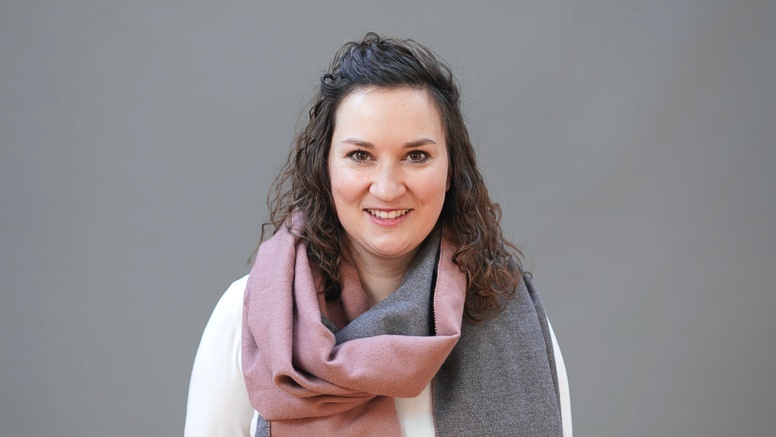 Porträt von Laura Bollack vor einem grauen Hintergrund