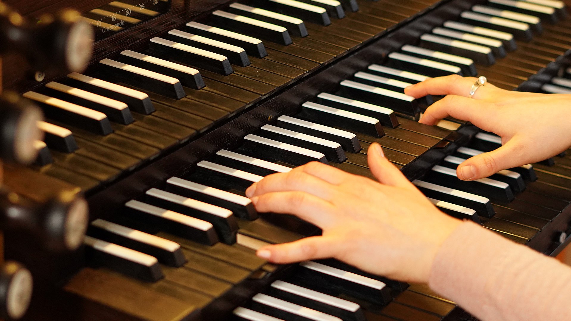Zwei Hände spielen auf einer Orgel
