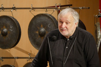 Schlagzeug-Professor Bernhard Wulff bei einer Rede, im Hintergrund mehrere Gongs