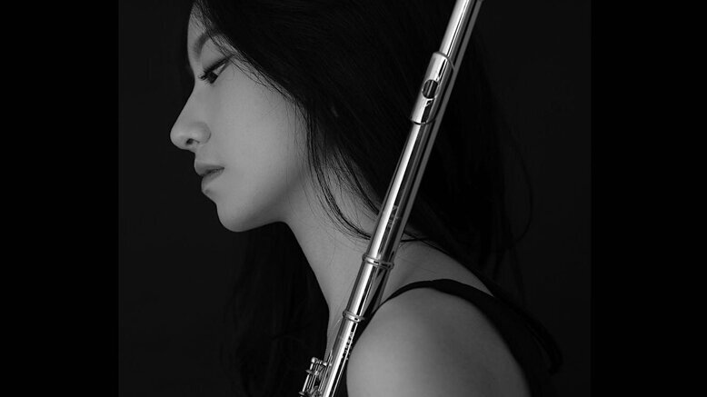 Schwarz-weiß Foto der Studentin Minjin Cho mit Querflöte