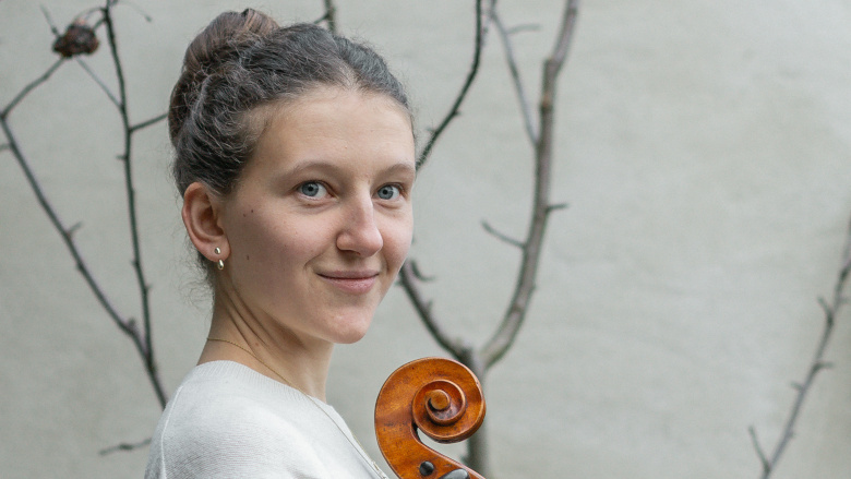 Die Cellistin Lara Jakobi ist vor einem grauen Hintergrund zu sehen