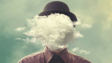 Mann mit Kopf in den Wolken
