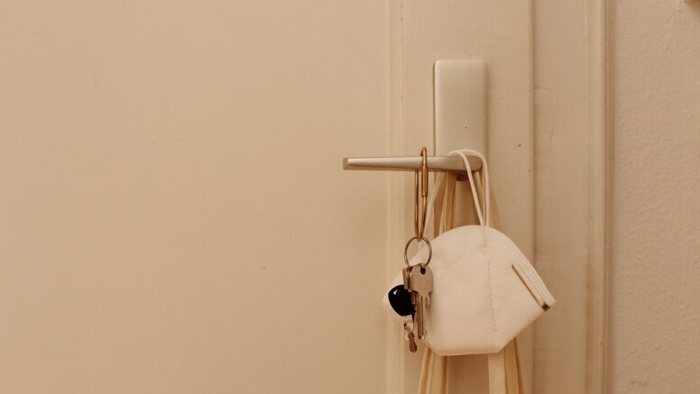 FFP2-Maske hängt an einer Türklinke