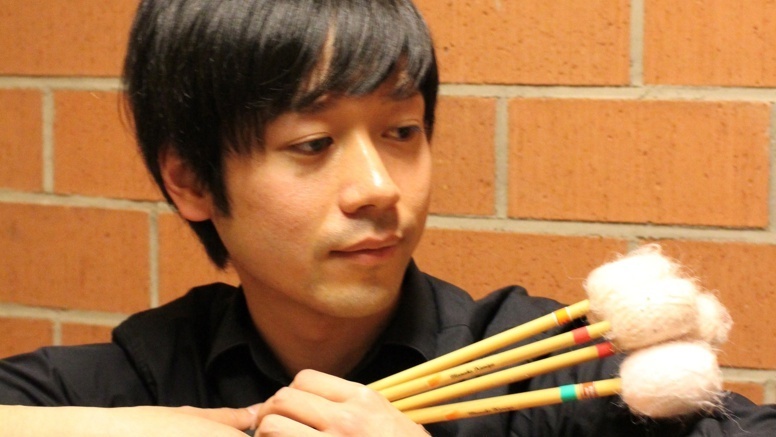 Ryu Shimizu mit Schlagzeugschlegeln in der Hand
