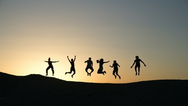 Springende Menschen beim Sonnenuntergang