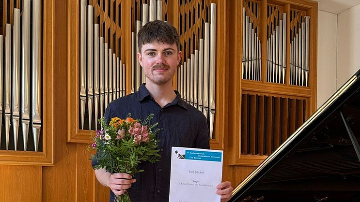Luis Jäckel mit Blumenstrauß und Urkunde