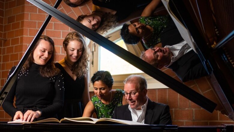 Studierende und Lehrende am Klavier