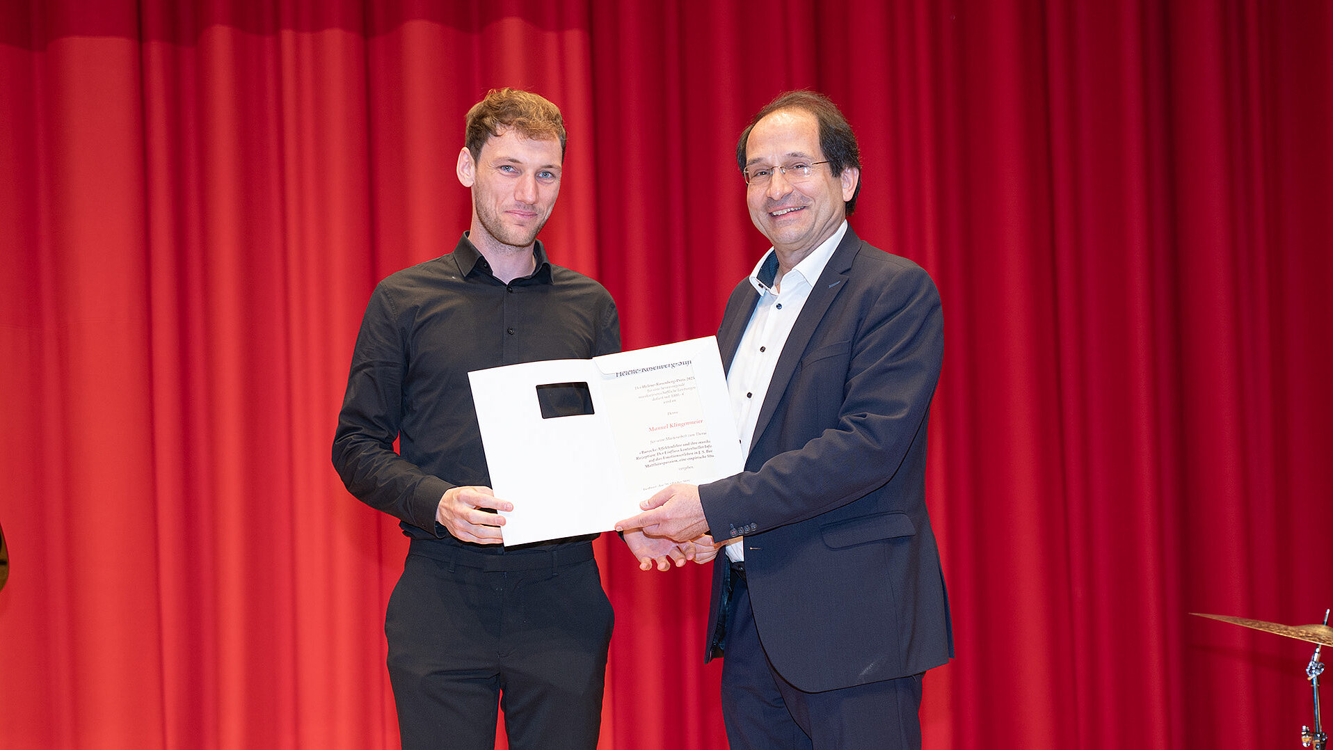 Christoph Sischka überreicht Manuel Klingenmeier seine Urkunde auf der Bühne des Konzertsaals