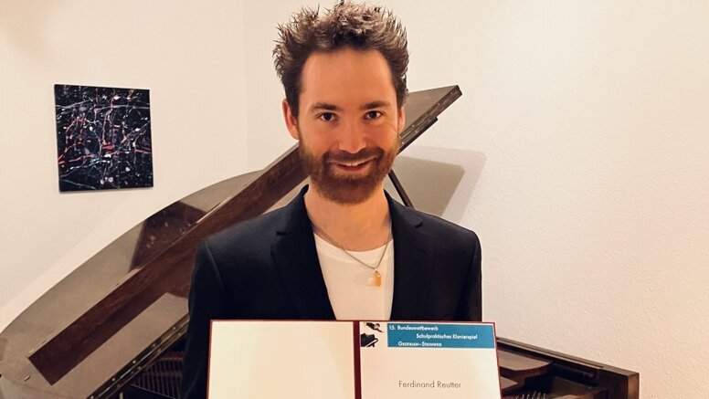 Ferdinand Reutter mit Urkunde vor Flügel