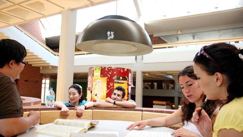 Studierende arbeiten an einem Tisch im Foyer der Hochschule
