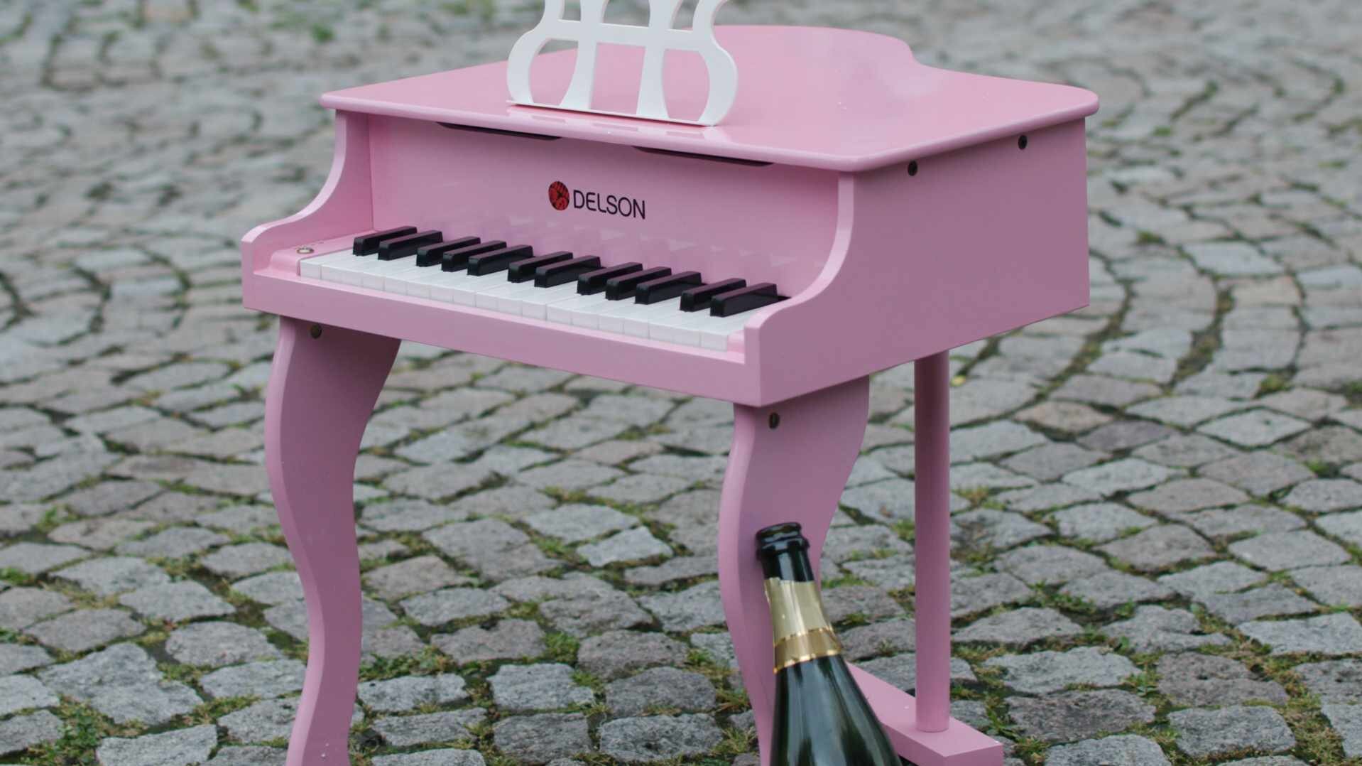Ein pinkes Spielzeugklavier steht auf dem Boden vor der Hochschule