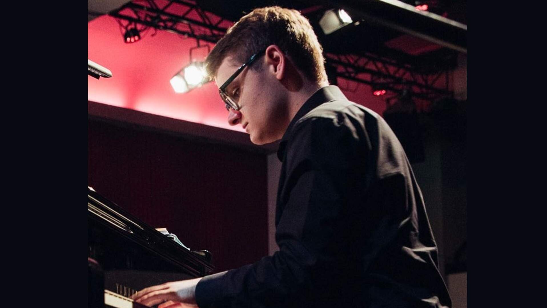 Linus Rebmann spielt an einem schwarzen Flügel bei einem Konzert