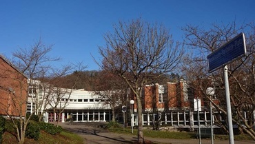 Blick von Außen, vor dem Haupteingang, auf die Hochschule