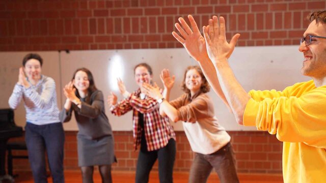Eine Gruppe tanzender Studierender im Rhythmiksaal der Hochschule klatscht im Takt