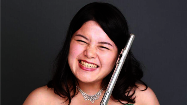 Eine lächelnde Yui Sakata mit ihrer Querflöte in der Hand