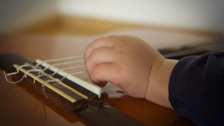 Babyhand auf Saiten