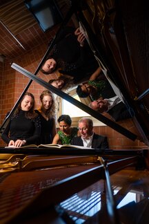 Studierende und Lehrende am Klavier