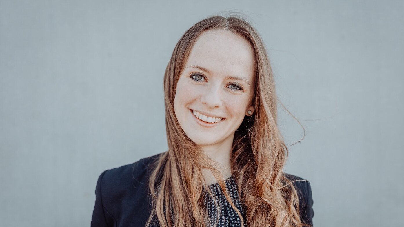 Man sieht Stefanie Kreuzwiesers Gesicht und den Oberkörper bis zu der Hälfte der Oberarmer. Sie trägt die Haare offen und hat einen schwarzen Blazer an.