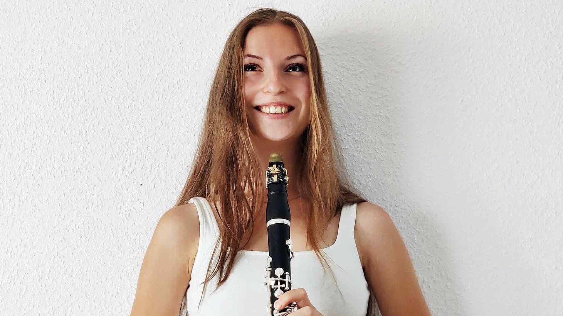 Irene Martínez Navarro mit Klarinette in der Hand vor einer weißen Wand