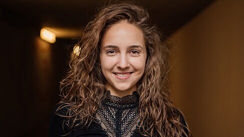 Man sieht das Gesicht und den Oberkörper von Natalie Beck. Sie trägt ein schwarzes Oberteil.